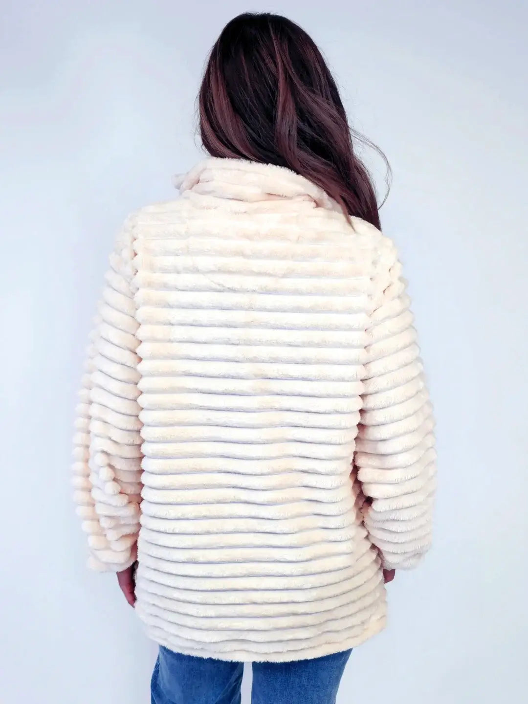 Woman wearing ivory Simply Luxe Pullover with ribbed texture, showcasing back view of cozy and stylish design in soft, ultra-plush material.