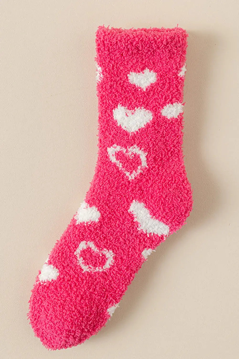 Cozy pink heart-patterned sock showcasing soft sherpa fleece and trendy crew length design. Perfect for adding warmth and style.