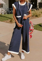 Model wearing the Harbor View two-piece navy pants set with white trim and front pockets, showcasing a coastal chic style.