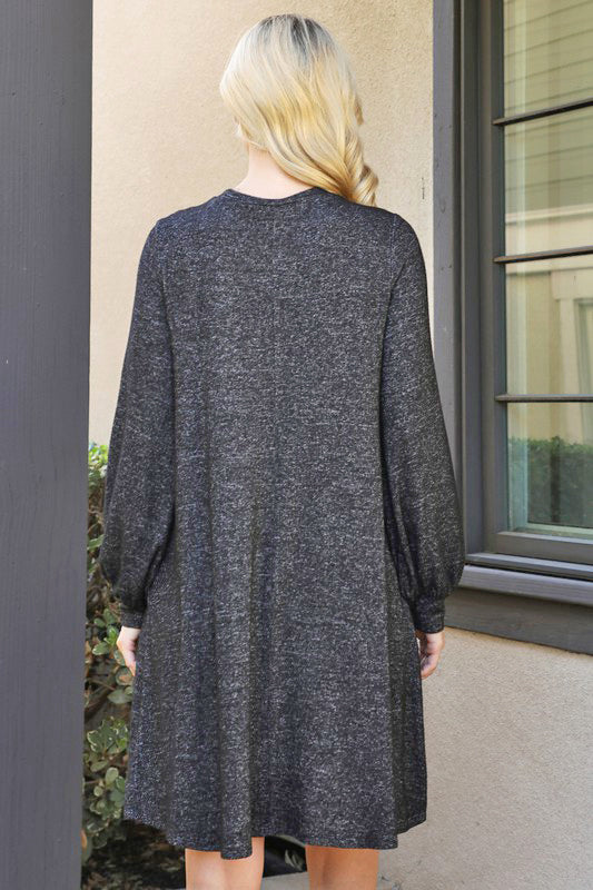 Woman wearing MIDNIGHT MUSINGS Dress in heathered black with puff sleeves, showcasing back view and comfortable fit.