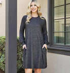 Woman wearing MIDNIGHT MUSINGS Dress in heathered black with puff sleeves and pockets, showcasing chic style and comfort.