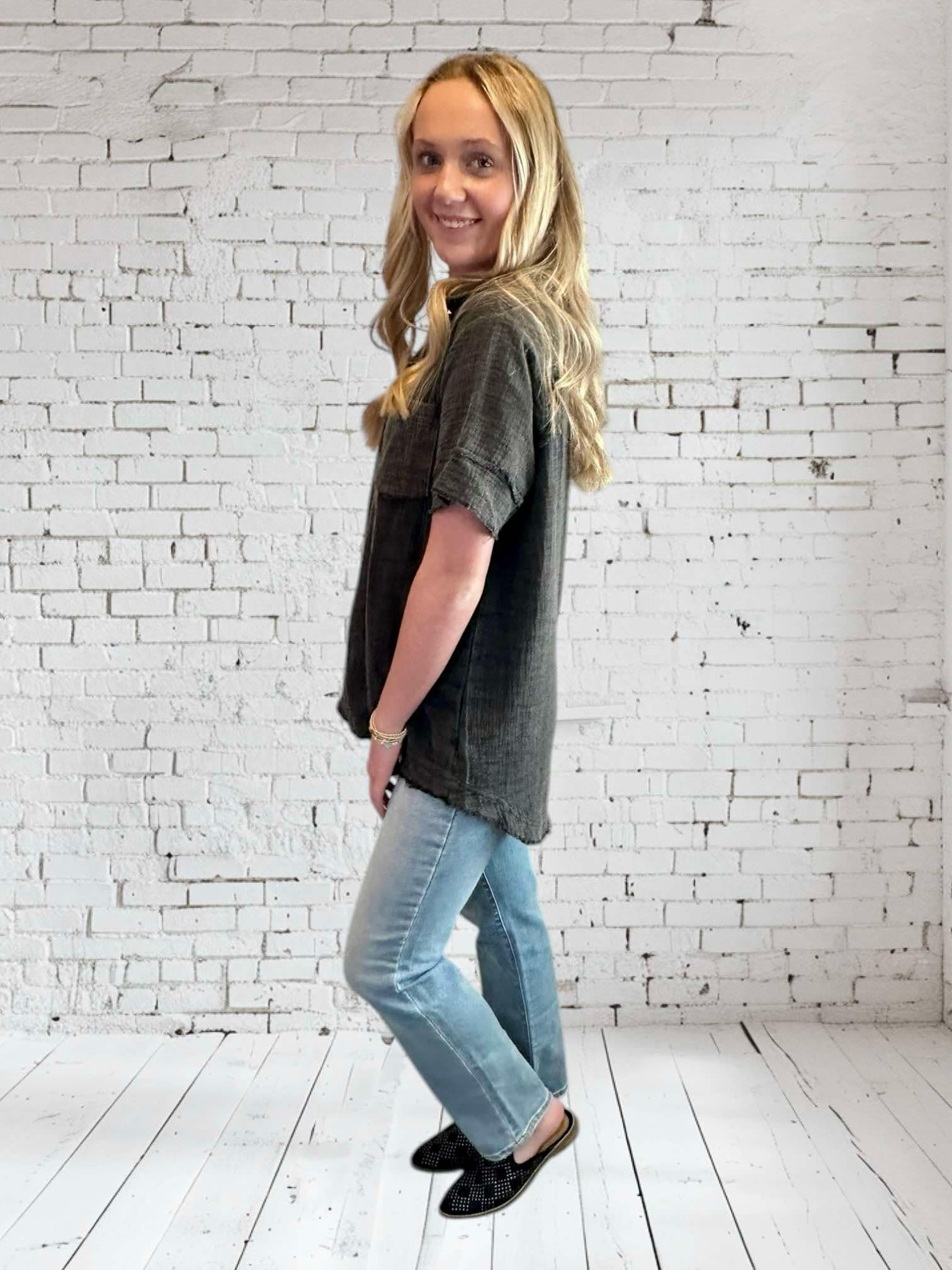 Model showcasing the Midnight Mist top by Umgee, featuring a V neckline and frayed hem, styled with jeans.