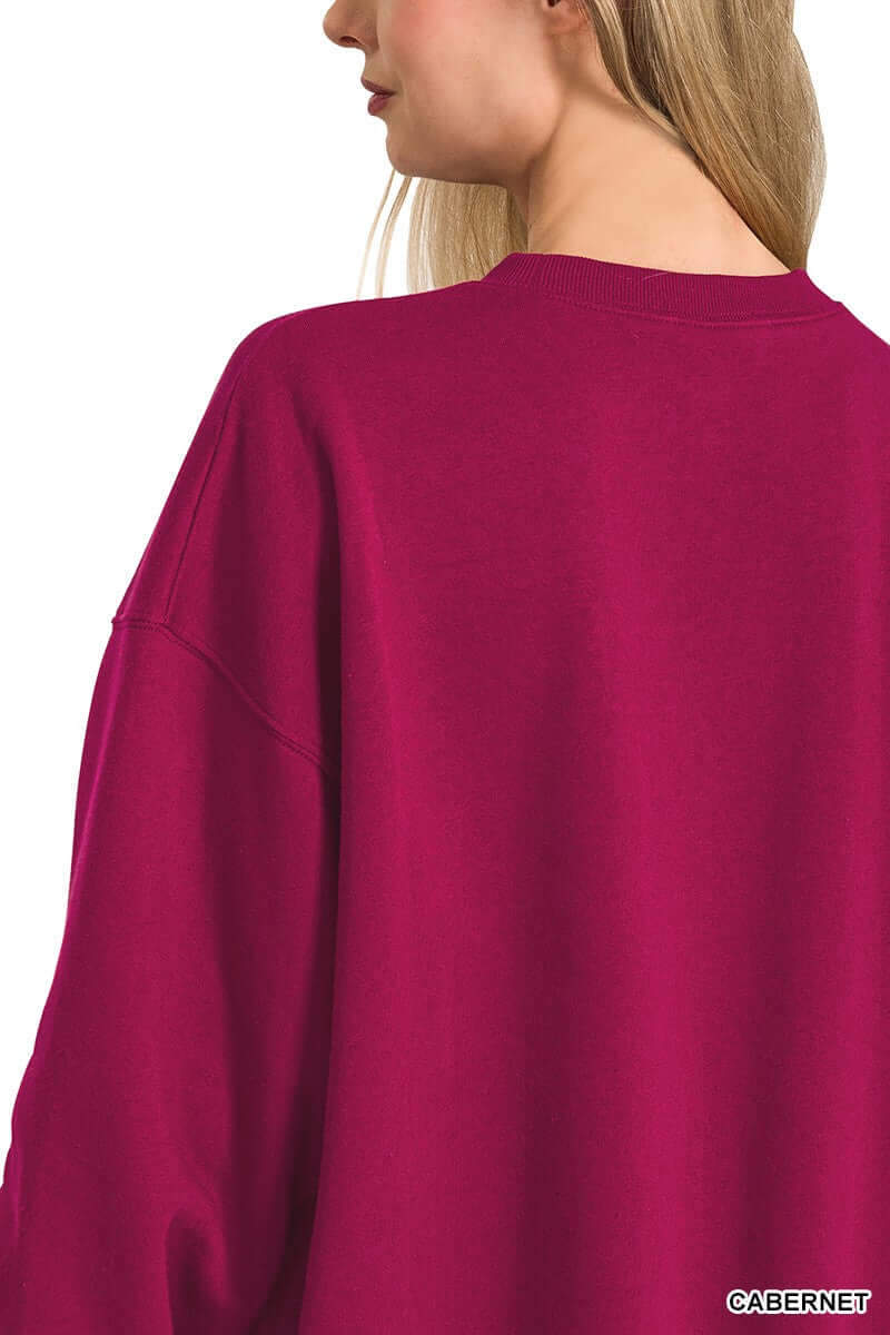 Back view of a woman wearing the HEARTHSIDE MOMENTS PULLOVER in vibrant cabernet color, showcasing its relaxed fit.