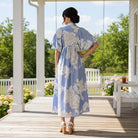 JUST BREATHE MAXI DRESS (misty blue) - Gigio showcased outdoors, highlighting its floral design and flowing silhouette.