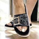 Black eyelet-embroidered Corkys sandals with bold bamboo-style buckle for summer elegance.