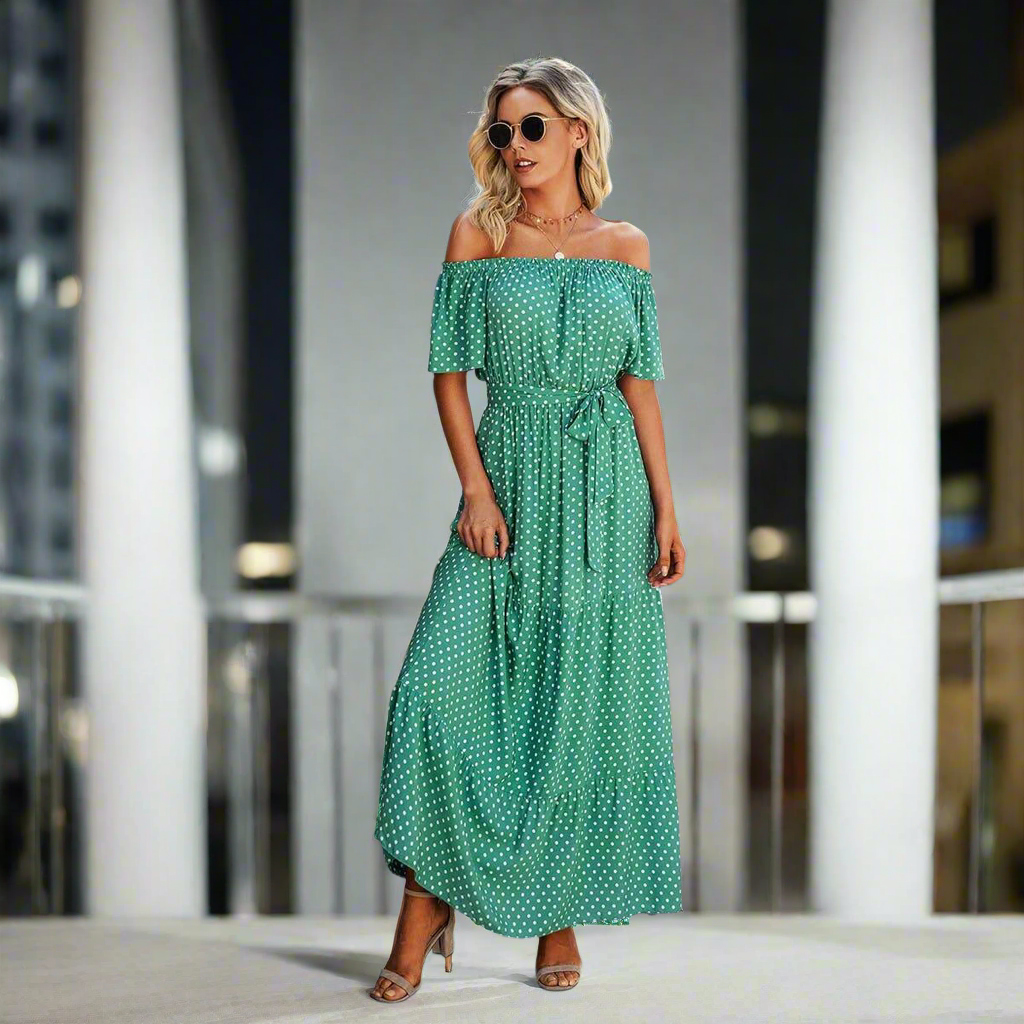 Green polka dot ON THE DOT MAXI DRESS with off-the-shoulder style, ruffles, and a flattering belt, perfect for any occasion.