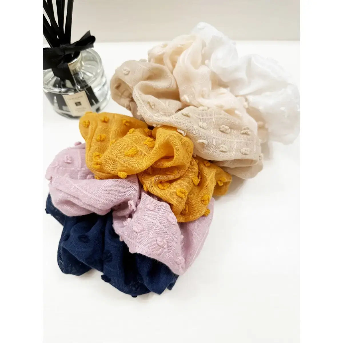 Colorful Cloud Comfort Scrunchies in pompom texture: navy, pink, yellow, beige, and white, perfect for stylish hair ties.