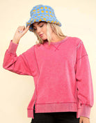 Model wearing pink Flex Time Crew Neck sweater with relaxed fit and blue hat, showcasing modern style and comfort.