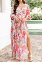 Model wearing Tropical Sensation Dress with floral print and high slit, perfect for summer occasions.