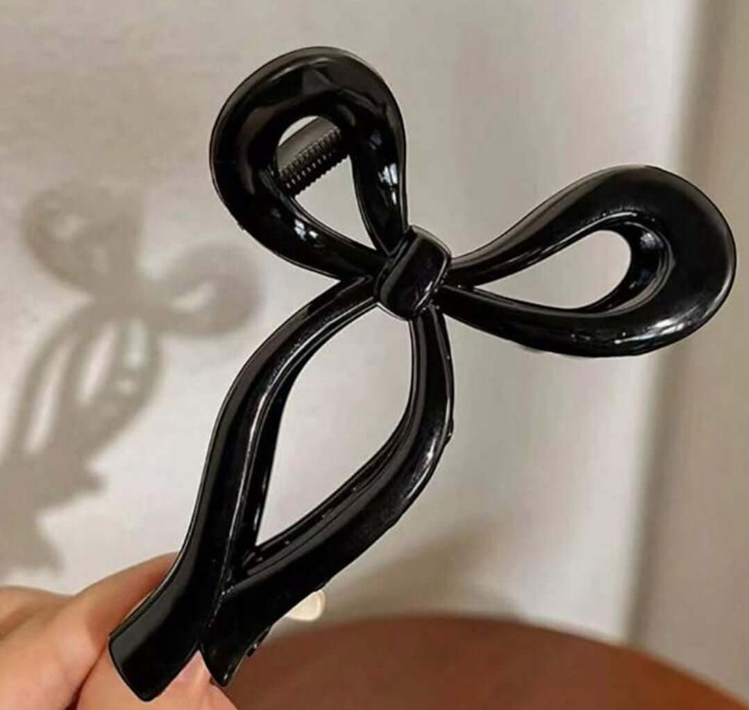 Chic black bow-shaped Tied and True hair clip for stylish hairdos and secure hold.