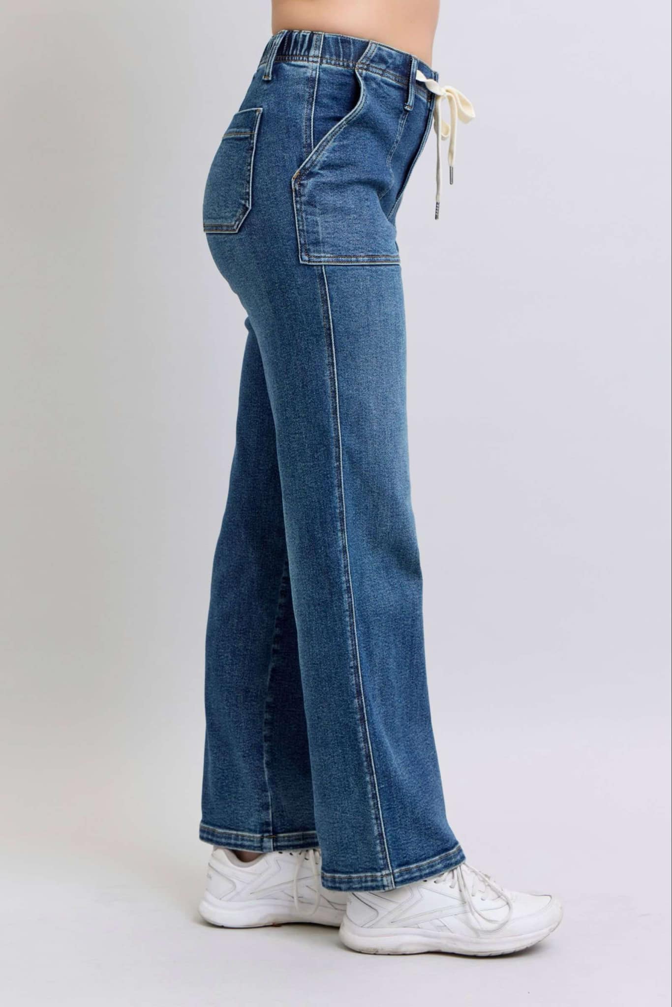 Side view of JUDY BLUE-SOPHIA JEANS with high waist, wide leg, and drawstring detail, showcasing comfort and style.