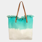 Two tone square tote bag with turquoise and white design, featuring fringed top and brown handles, perfect for casual outings.