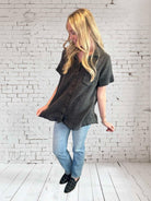 Woman wearing a stylish Midnight Mist top by Umgee, featuring a V neckline and frayed hem, paired with jeans.