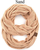 Cozy C.C Story Book knitted infinity scarf in sand color, featuring a stylish cable knit design. Perfect for warmth and comfort.