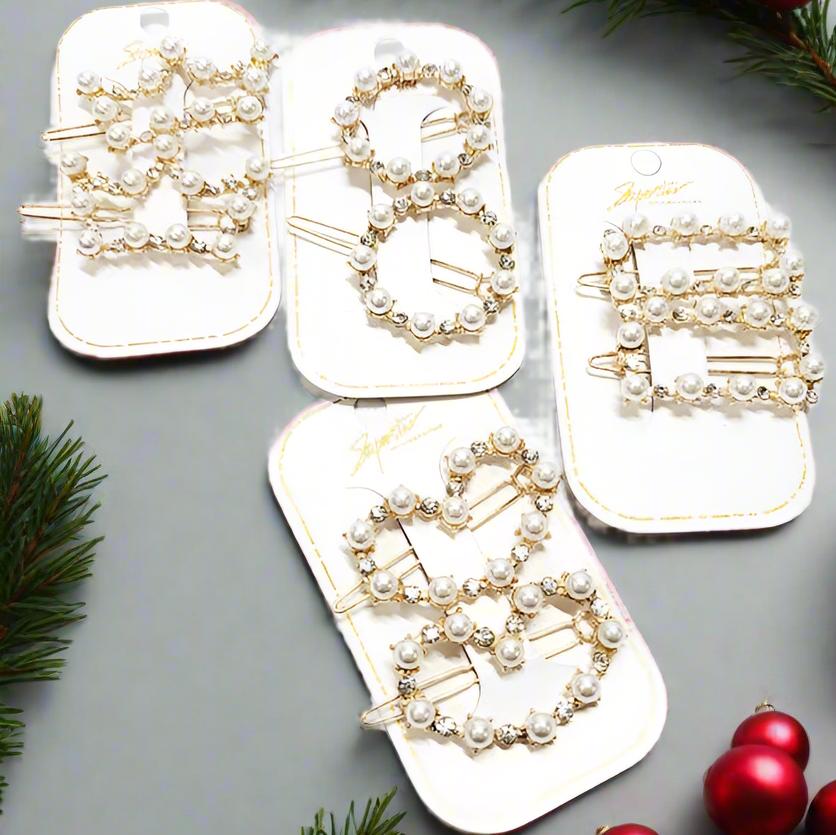 Set of two gold tone pearl and rhinestone barrettes in heart and rectangle shapes, perfect for holiday styling.