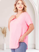 Model wearing the Softest Rose Tee by Zenana, a comfy plus size v-neck top in soft pink.