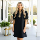 BOLD MOVES DRESS featuring a sleek zip-up collar and leopard trim, showcasing confidence and style.