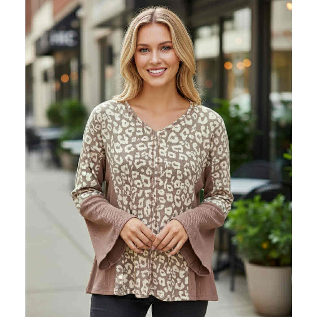 Woman wearing the UNTAMED SPIRIT TOP (irish mocha) with leopard print and bell sleeves.