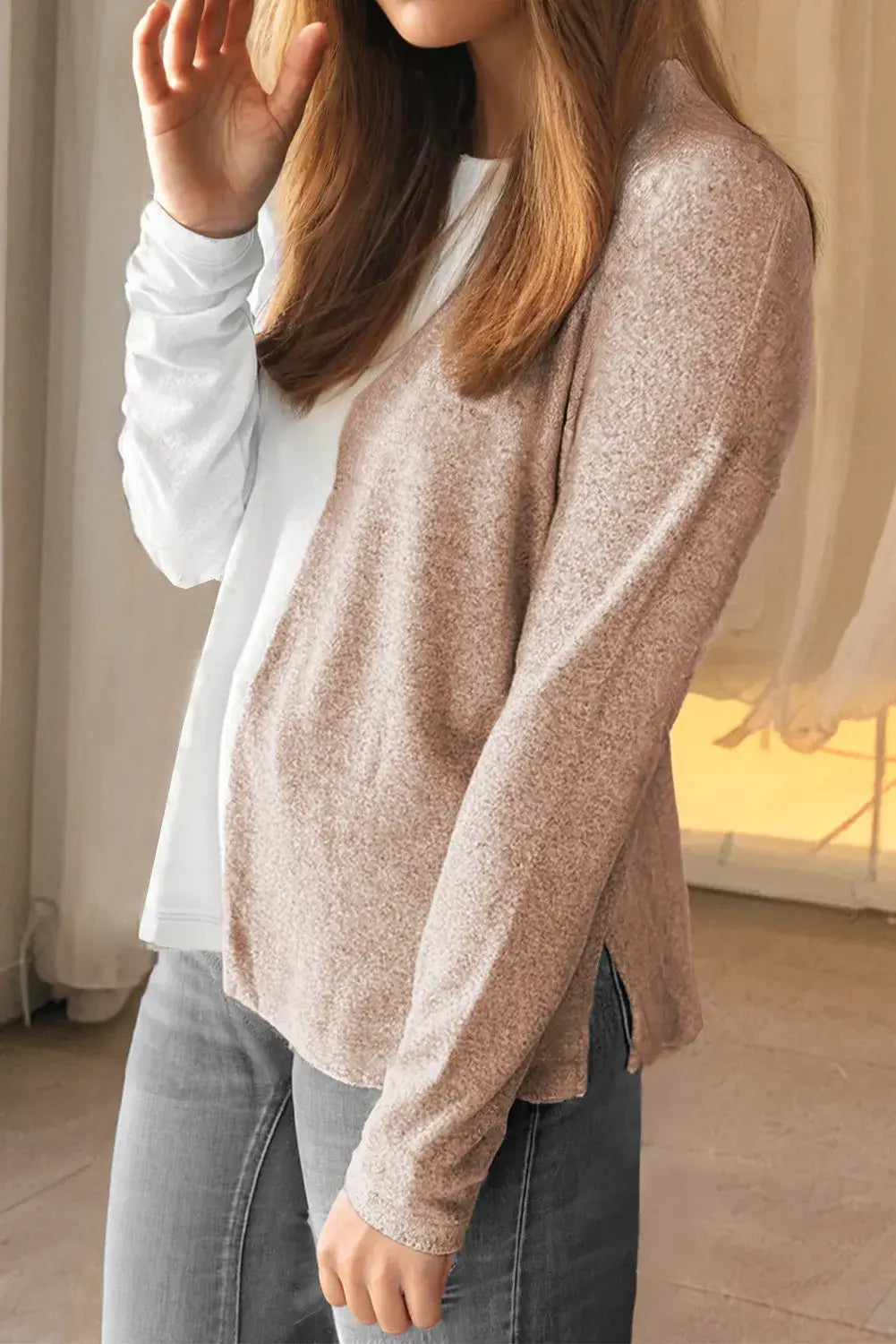 Woman wearing a cozy colorblock knit top with long sleeves and a crew neck, showcasing a stylish casual look.