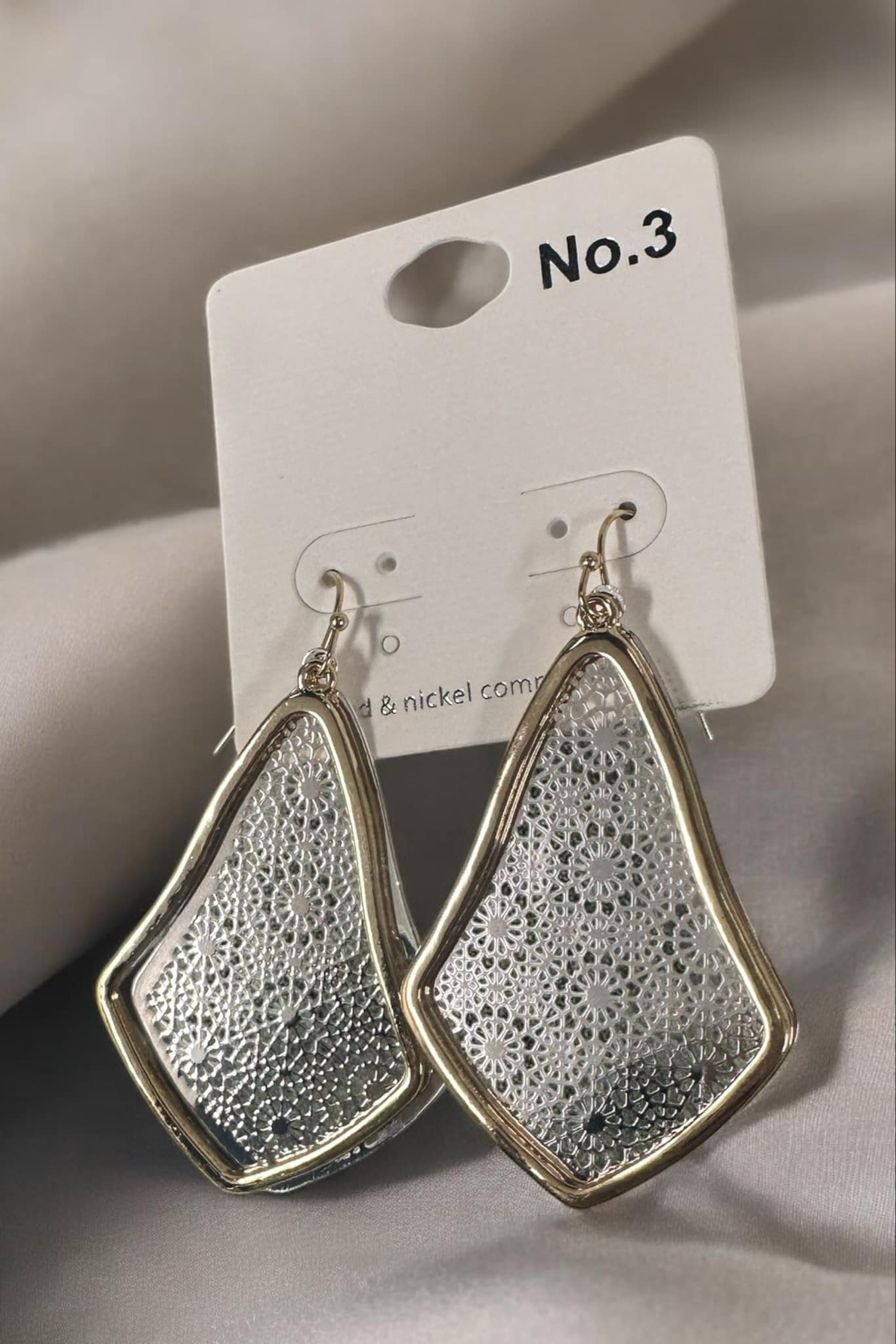 Silver and gold Contessa Teardrop earrings by No 3 Jewelry with mandala pattern and fishhook backs on a display card.