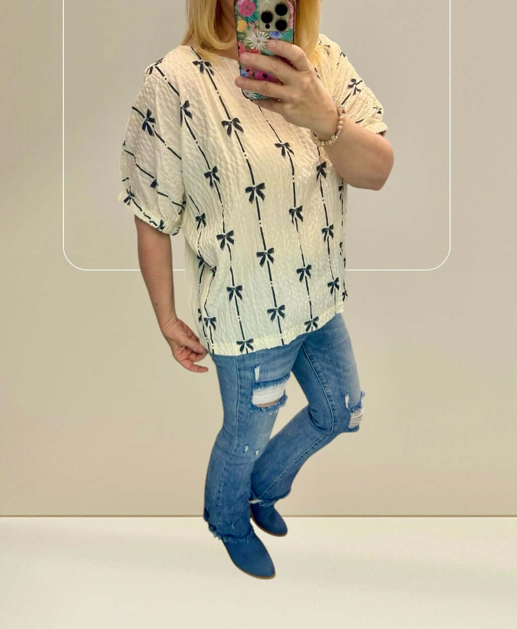 Stylish Ribbons in the Sand Top featured with palm print, paired with ripped jeans and boots.