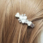 Pearl accent hair clip styled in light brown hair on a mannequin, showcasing a delicate floral design.