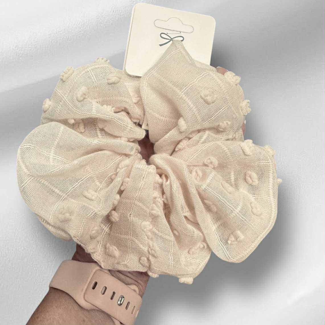 Cloud Comfort Scrunchie in soft beige with pompom texture, perfect for stylish hair ties and cozy wrist accessory.