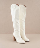 White knee-high boots by Oasis Society with high heel, perfect for fashion-forward cowgirls. Timeless slip-on design perfect for any occasion.