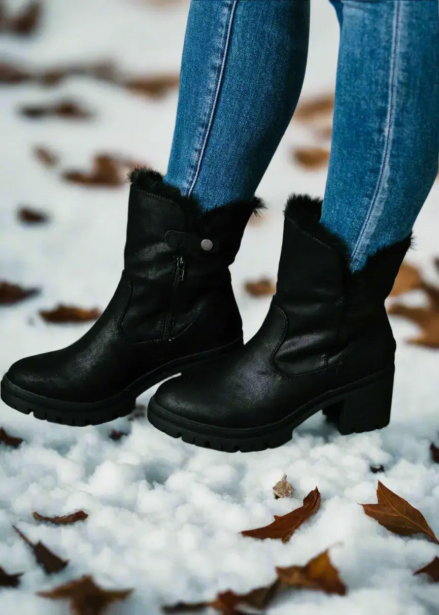 Cozy Very G North Park black boots with faux fur lining, styled with jeans on snowy ground, showcasing versatile fashion.