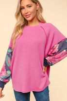 Woman wearing SWEET PEA RIBBED TOP by Haptics in magenta with navy floral sleeves, showcasing cozy oversized fit and round neck design.