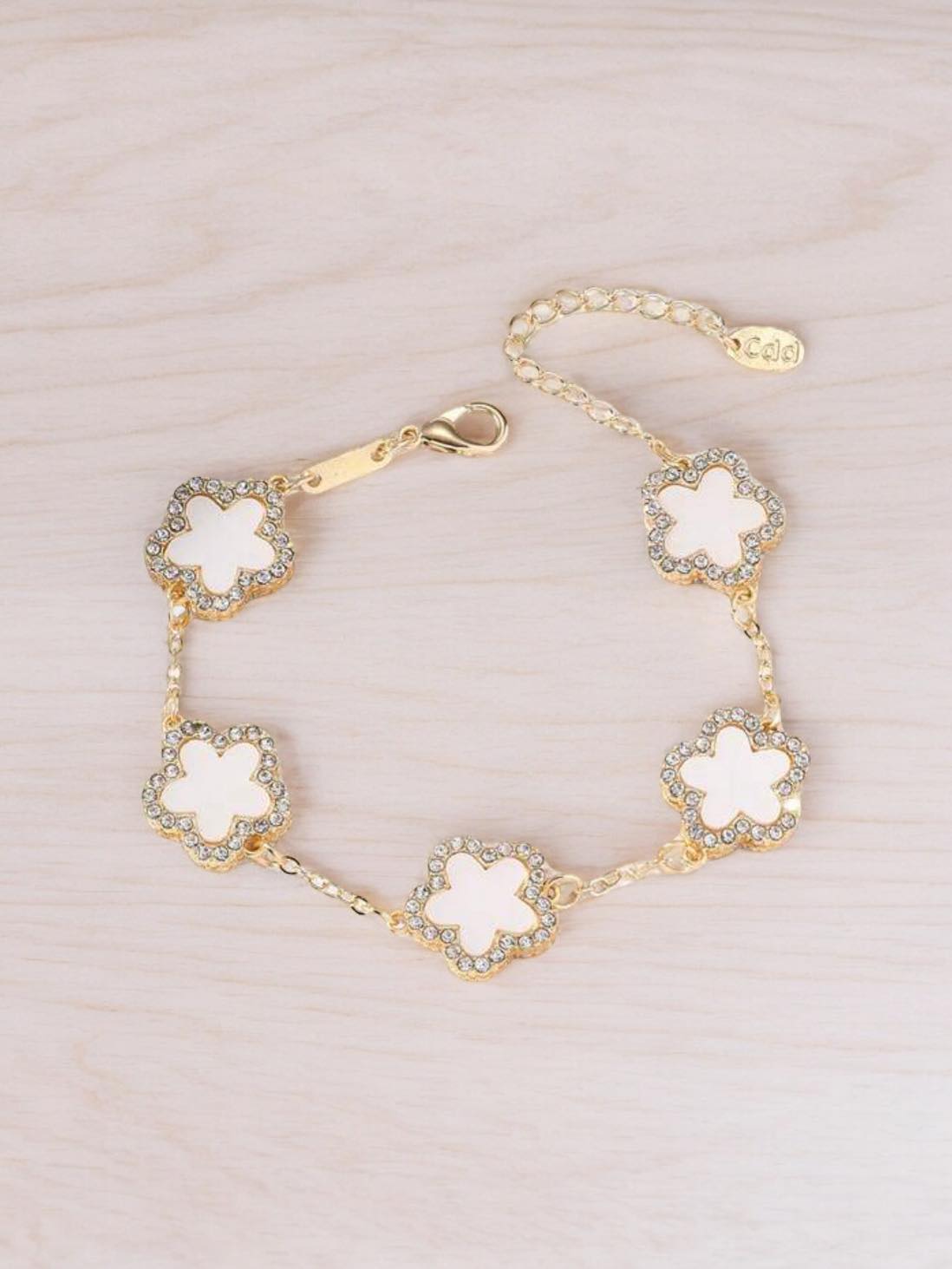 RHINESTONE CLOVER Bracelet (white) by Teal Tiger Boutique $14.00 Evoke sophistication and elegance with this luxurious white clover bracelet adorned with sparkling rhinestones, set against a beautiful gold-toned base. Teal Tiger Boutique