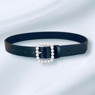 Pearl Accent Belt (black) by Teal Tiger Boutique $15.00 Indulge in the luxurious elegance of our black belt, adorned with a square faux pearl buckle and highlighted by a stunning gold tone underlay. 1.2 inches wide and 40 inches long Teal Tiger Boutique