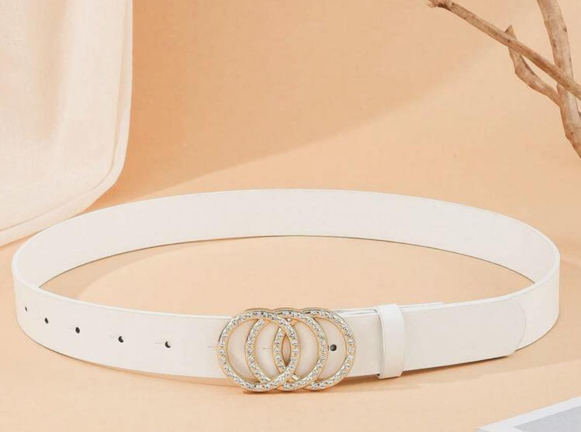 Rhinestone Circles Belt (white) by Teal Tiger Boutique $16.00 Indulge in the luxurious elegance of our white belt, adorned with round rhinestone circles and highlighted by a stunning gold tone underlay. 1.25 inches wide and 38 inches long Teal Tiger Bouti