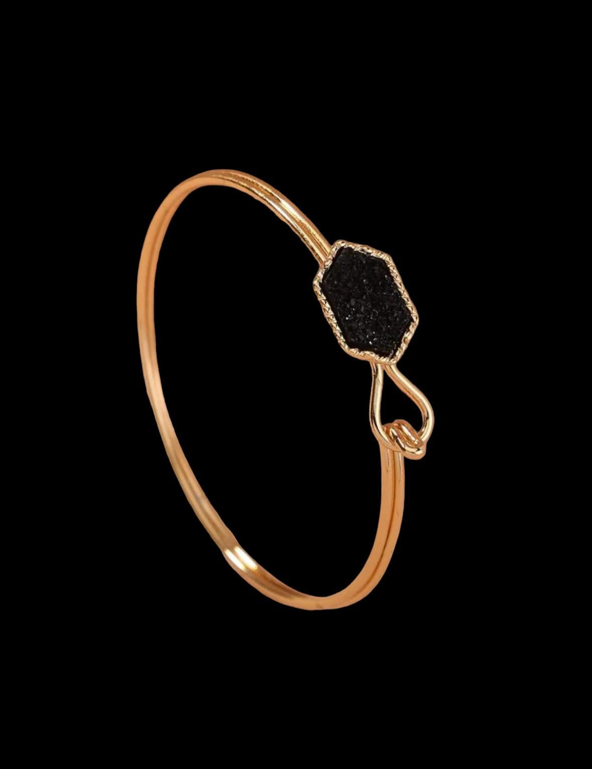 SPARKLING SABLE bracelet featuring a sable geometric stone, gold-tone bangle, and elegant hook closure.