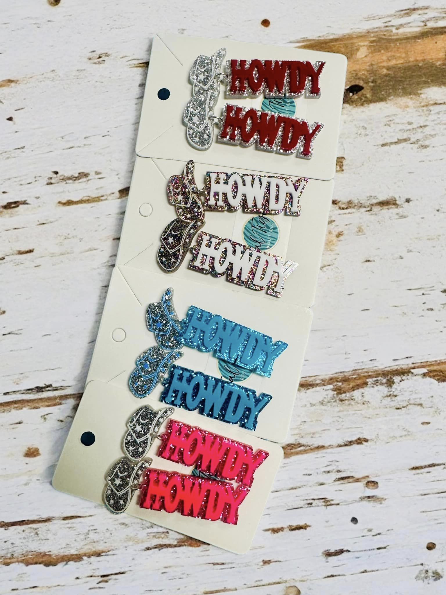 Colorful HOWDY earrings in blue, red, pink, and silver, perfect for western-themed events and country concerts.