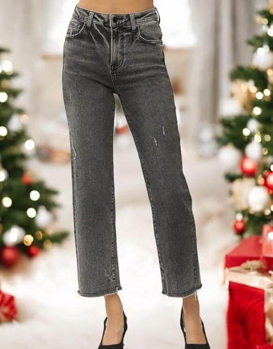 Risen Veronica Jeans in acid wash black with frayed hem, styled for a festive setting with holiday decorations.