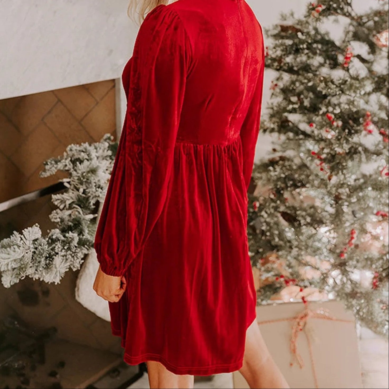A woman in a red velvet dress poses in front of a Christmas tree, showcasing the SPARKLE SEASON VELVET DRESS (Holiday Red).