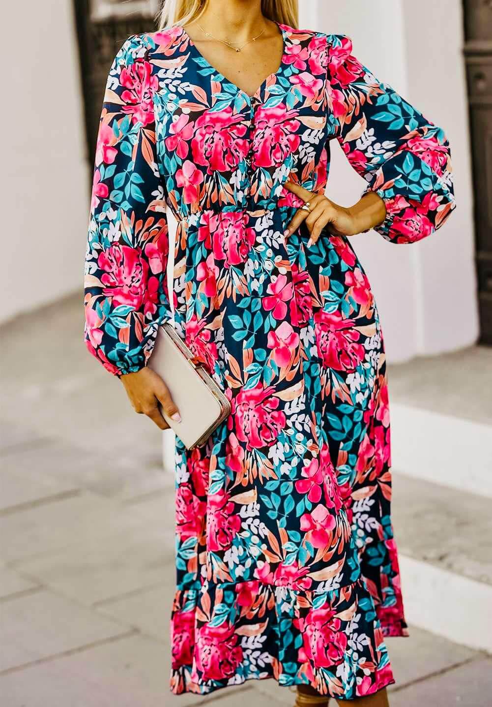 Model wearing a floral V-neck dress with balloon sleeves, showcasing vibrant colors and stylish design.