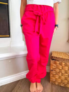 Fuchsia Pink Power Joggers with belt, elastic waist, cuffs, and pockets, perfect for casual wear.