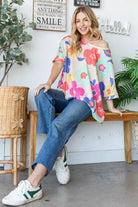 Model wearing 'Hope Blooms' floral oversized top with blue jeans, showcasing a vibrant, whimsical style.