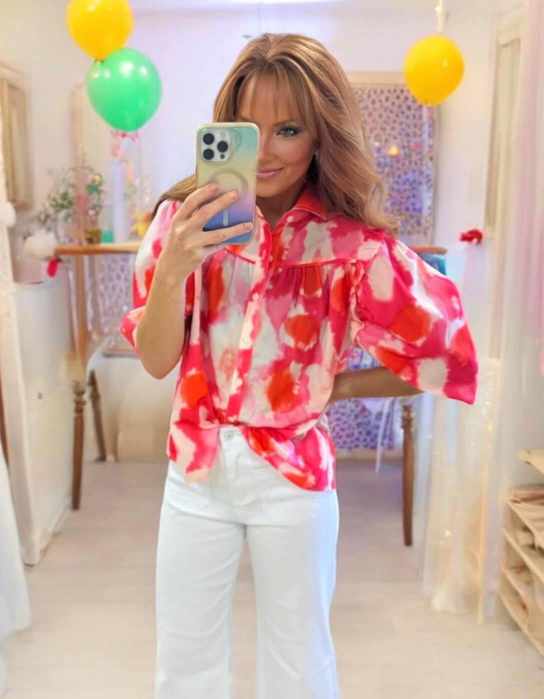 BLENDED BEAUTY TOP - Trendy, Stylish Blouse by Vivian-Lu $36.00 Discover the BLENDED BEAUTY TOP, a chic blouse with a pink abstract pattern, frilled ruffles, and half sleeves. Perfect for comfort and style from our boutique. Teal Tiger Boutique