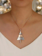 Two-tone Christmas tree pendant necklace worn on a model, perfect for holiday outfits and festive occasions.