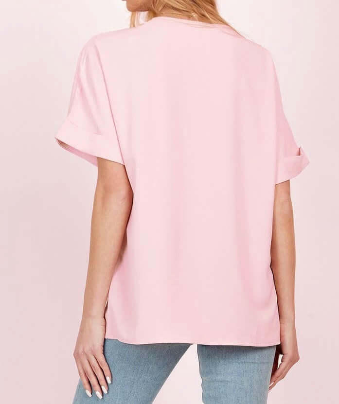 Back view of the DAYBREAK DARLING Top in soft pink, featuring short sleeves and a loose fit, perfect for casual chic outfits.