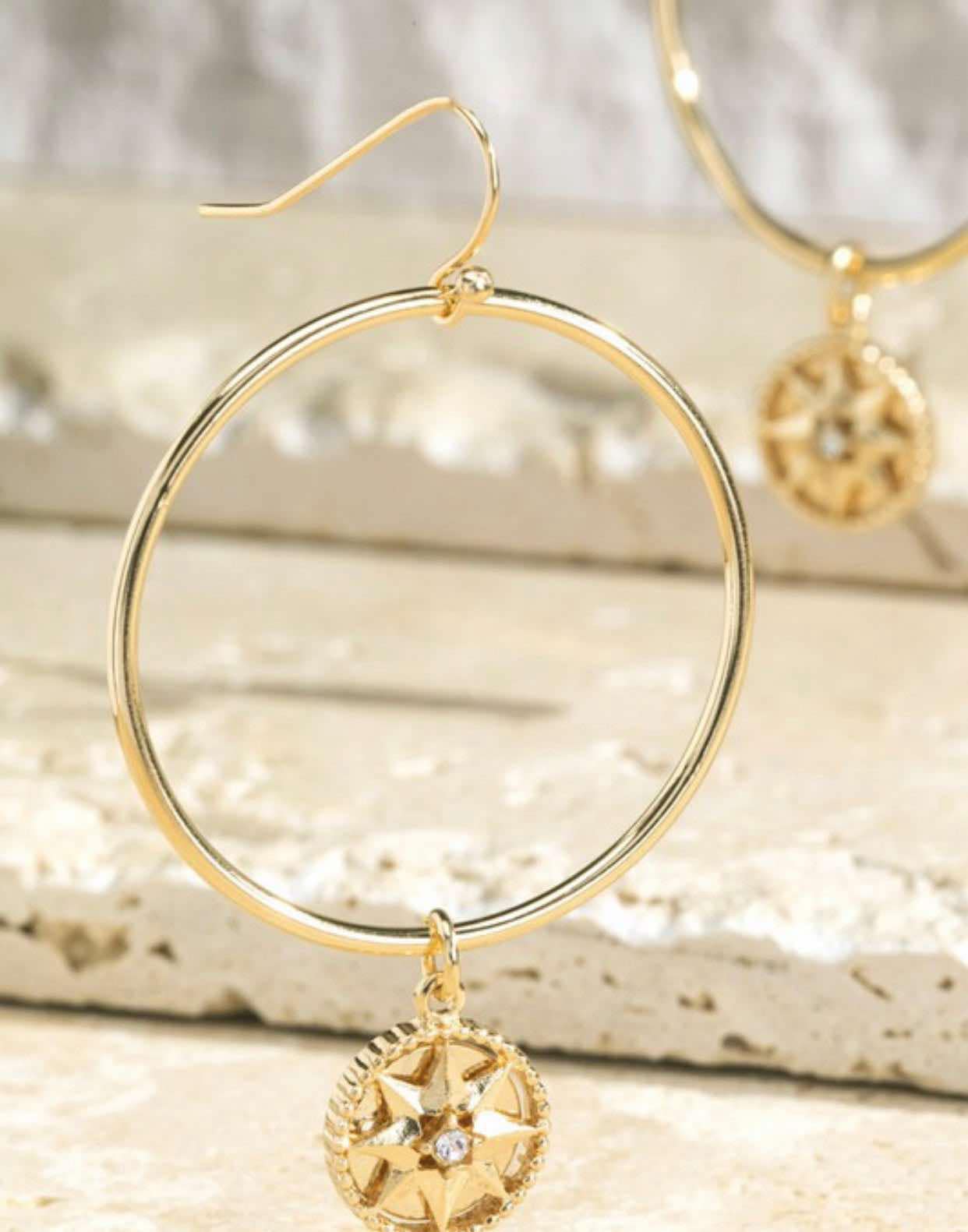 Natural Balance Earrings by [Brand Name], gold-tone circle with rhinestone-star center, French hook style, elegant jewelry.