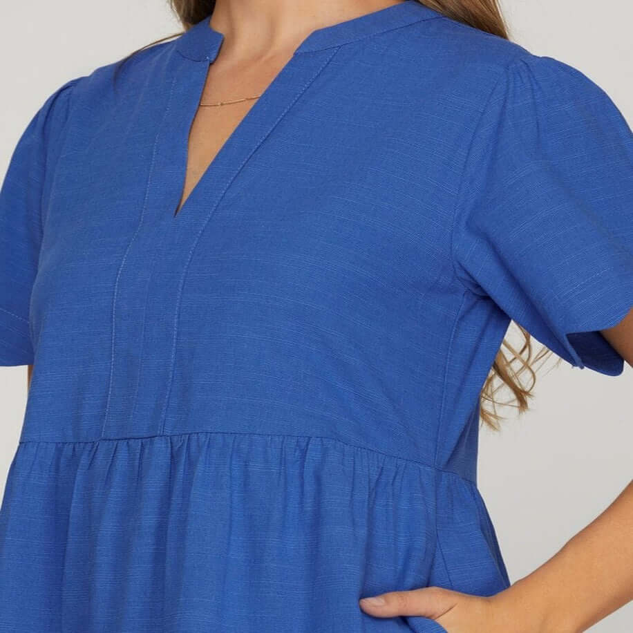 Close-up of the Coastal Curves Dress showcasing V-notch neckline and puff sleeves in vibrant cobalt blue.