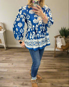 Boho chic V-neck blouse in cobalt blue with white patterns, paired with jeans for a stylish, casual look.