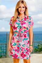 Model wearing the Garden Getaway Dress featuring vibrant watercolor florals and a stylish self-tie belt.