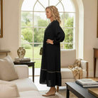 Graceful Instincts Maxi Dress showcased in elegant living space with black collared v-neck and leopard trim.