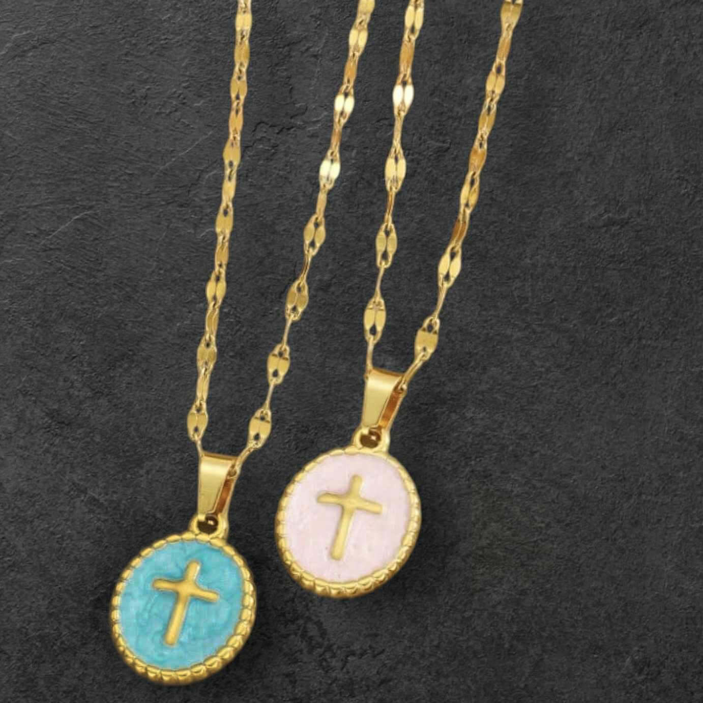 Gentle Grace necklace featuring gold-tone cross pendants in blush pink and teal blue enamel