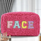 Pink plush chenille cosmetic bag with colorful chenille patch letters spelling 'FACE' and gold accents.